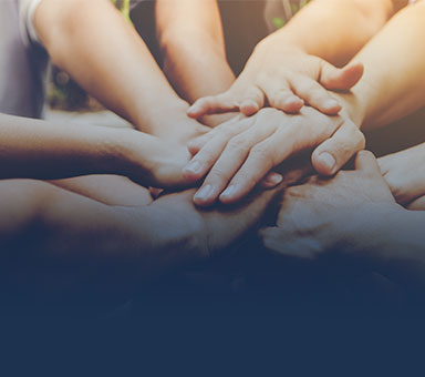 Vereinte Hände, die übereinander gestapelt sind.